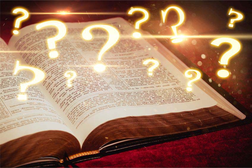 Photo of Open Bible with Question Marks Floating Up form its Pages